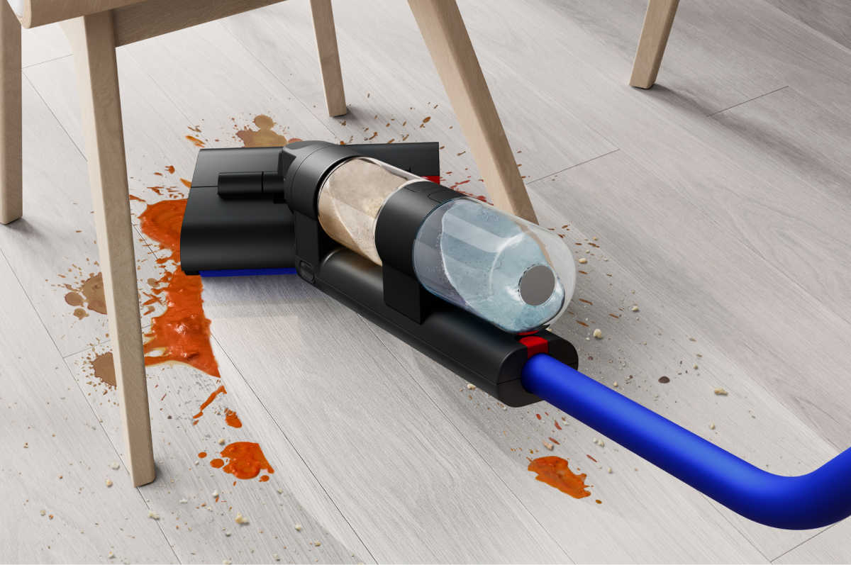 A close-up of the WashG1 reaching low to reach food spills under a kitchen table.
