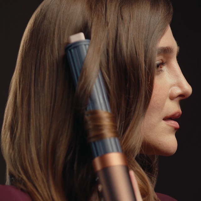 Model curls her hair with the Dyson Airwrap Co-anda2x multi-styler and dryer.