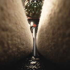 The Dyson V8 Cyclone vacuum is used with the Crevice tool to clean between cushions on a sofa.