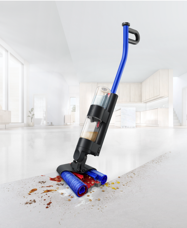 The Dyson WashG1 wet cleaner moving over wet and dry dirt, leaving a clean sweep behind it.