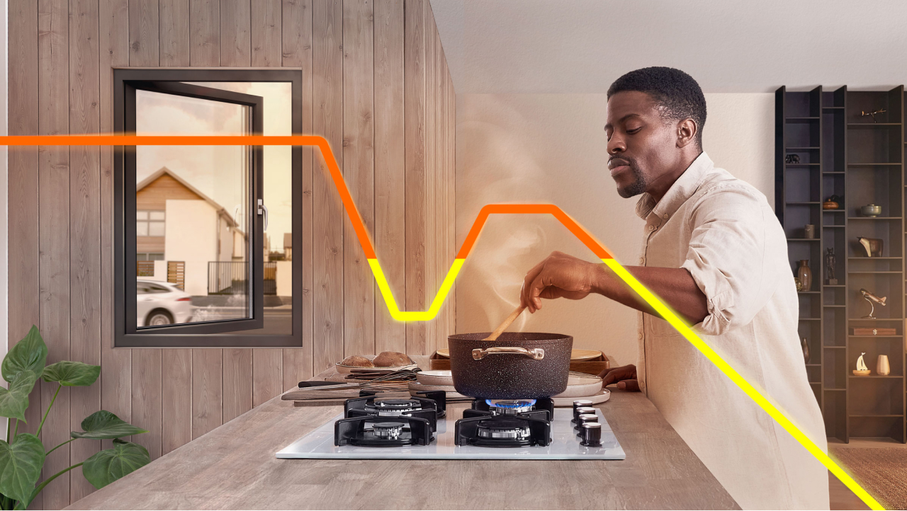 A person cooking on a gas stove, with an open window in the background