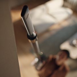 The Dyson V8 Cyclone vacuum is used with wand and Crevice tool to clean up high in a home.