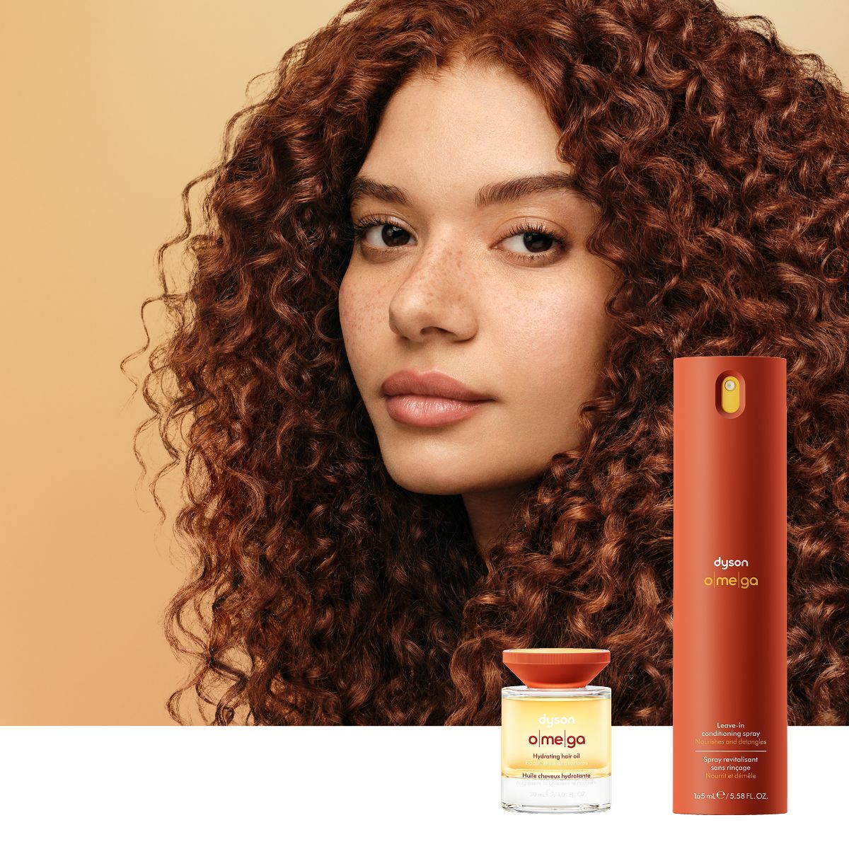 Model with nourished hair behind the Dyson Omega nourishing range.